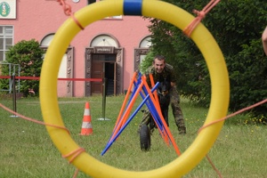 Funkcjonariusz z psem podczas biegu z przeszkodami