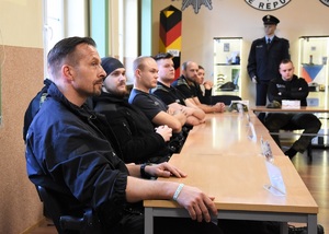 Funkcjonariusze SG oraz Policji Federalnej RFN siedzą przy stole w sali wykładowej
