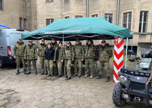 Zdjęcie grupowe funkcjonariuszy SG biorących udział w pikniku stojących przed namiotem