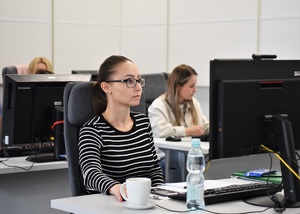 Uczestniczka szkolenia siedzi przy komputerze w sali wykładowej
