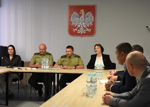 Dwóch Komendantów Ośrodka oraz przedstawiciele OBWE oraz Republiki Kirgistanu w sali odpraw Ośrodka. W tle godło RP