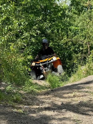 Funkcjonariusz SG na pojeździe ATV w trakcie jazdy w terenie