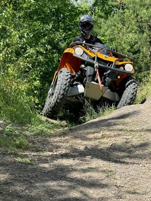 Funkcjonariusz SG na pojeździe ATV w trakcie jazdy w terenie