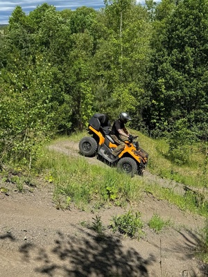 Funkcjonariusz SG na pojeździe ATV w trakcie jazdy w terenie