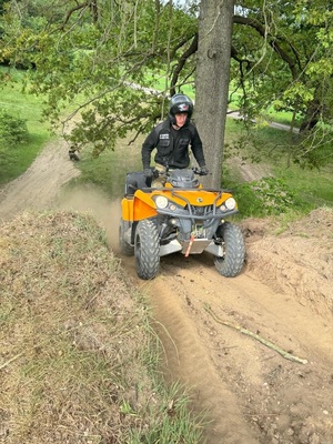 Funkcjonariusz SG na pojeździe ATV w trakcie jazdy w terenie