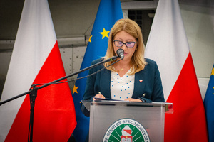 Wiceburmistrz Lubnia podczas przemowy, w tle flagi Polski i Unii Europejskiej