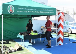 Funkcjonariuszka SG oraz uczestnik pikniku przy stoisku promocyjnym SG