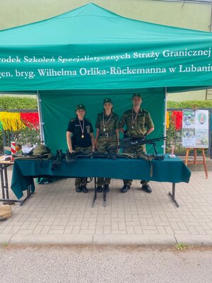 Trzech funkcjonariuszy SG przy stanowisku promocyjnym