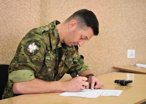 Kursant szkolenia w zakresie szkoły podoficerskiej podczas egzaminu w sali wykładowej