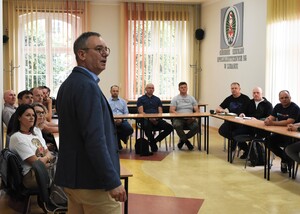 Prowadzący, w tle uczestnicy warsztatów w sali wykładowej