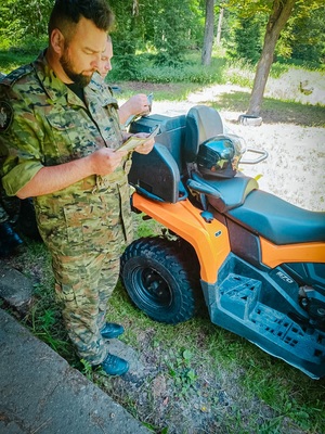 Funkcjonariusze SG w trakcie zajęć w terenie w tle pojazd ATV